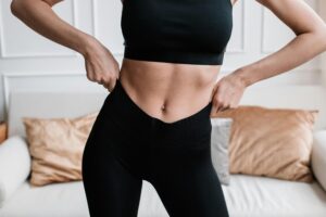 Flat stomach after tummy tuck vs liposuction recovery results.